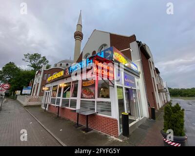 Essen. 27 mai 2021. Firo : 27 mai 2021 la mosquée Fatih est, avec d'autres hôtes de prière islamiques, la seule mosquée architecturale d'Essen. C'est là que la salle de prière et les salles de club de la communauté Tvºrk de la région de Katernberg Ruhr sont situés, caractéristique, dépôt, arrière-plan Essen en face d'elle une publicité de poulet chaud poisson frais local néon publicité sur Schalkerstravue dans la religion rencontre le commerce, Contraste d'un Grovustadt dans le Revier, changement dans le temps et les cultures dans NRW/dpa/Alamy Live News Banque D'Images