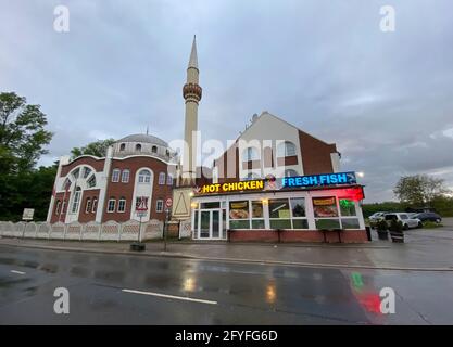 Essen. 27 mai 2021. Firo : 27 mai 2021 la mosquée Fatih est, avec d'autres hôtes de prière islamiques, la seule mosquée architecturale d'Essen. C'est là que la salle de prière et les salles de club de la communauté Tvºrk de la région de Katernberg Ruhr sont situés, caractéristique, dépôt, arrière-plan Essen en face d'elle une publicité de poulet chaud poisson frais local néon publicité sur Schalkerstravue dans la religion rencontre le commerce, Contraste d'un Grovustadt dans le Revier, changement dans le temps et les cultures dans NRW/dpa/Alamy Live News Banque D'Images