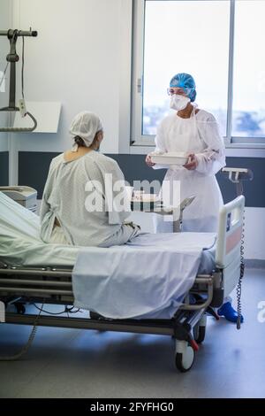 Infirmière dans la chambre d'un patient âgé, unité d'hospitalisation Covid du CHU de Limoges. Banque D'Images