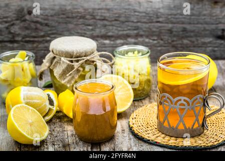 Thé au citron sur fond de bois. Ingrédients dans des pots en verre, gingembre et miel. Banque D'Images