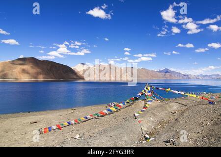 Drapeaux de prière bouddhistes volant à Pangong tso (lac).C'est un immense lac dans l'Himalaya situé à la frontière de l'Inde et de la Chine.Lacs s'étend jusqu'au Tibet. Banque D'Images