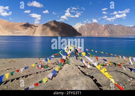 Drapeaux de prière bouddhistes volant à Pangong tso (lac).C'est un immense lac dans l'Himalaya situé à une hauteur d'environ 4 350 m (14 270 pi).134 km de long. Banque D'Images