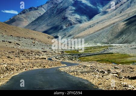 Une route en béton vers de belles montagnes rocheuses et ciel bleu avec des sommets de l'Himalaya, Leh, Ladakh, Jammu et Cachemire, Inde Banque D'Images