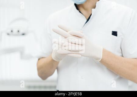 Fermer les mains du médecin dans des gants. Fabrication de gants en caoutchouc, la main humaine porte des gants en latex. Médecin portant des gants de protection en nitrile Banque D'Images