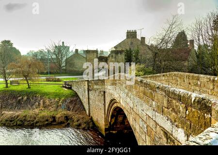 Ancien pont en pierre menant au village anglais de Warkworth, Northumberland Banque D'Images