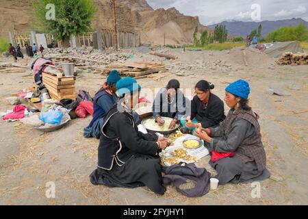 Mulbekh, Ladakh, Inde - 2 septembre 2014 : femmes tribales Ladakhi dans des robes traditionnelles coupant des légumes pour préparer la nourriture pour le festival religieux Banque D'Images