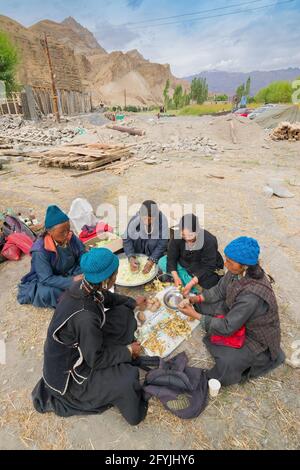 Mulbekh, Ladakh, Inde - 2 septembre 2014 : femmes tribales Ladakhi dans des robes traditionnelles coupant des légumes pour préparer la nourriture pour le festival religieux Banque D'Images