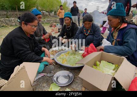 Mulbekh, Ladakh, Inde - 2 septembre 2014 : femmes tribales Ladakhi dans des robes traditionnelles coupant des légumes pour préparer la nourriture pour le festival religieux Banque D'Images