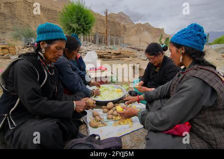 Mulbekh, Ladakh, Inde - 2 septembre 2014 : femmes tribales Ladakhi dans des robes traditionnelles coupant des légumes pour préparer la nourriture pour le festival religieux Banque D'Images