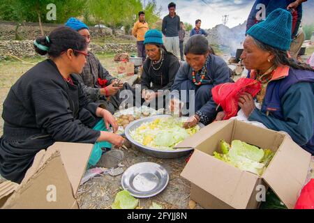 Mulbekh, Ladakh, Inde - 2 septembre 2014 : femmes tribales Ladakhi dans des robes traditionnelles coupant des légumes pour préparer la nourriture pour le festival religieux Banque D'Images