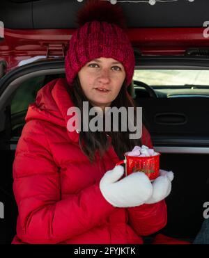 moufles blanches et une fille sous un manteau rouge Banque D'Images