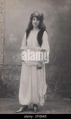 Carte postale photographique vintage montrant une fille habillée dans un costume turc Banque D'Images