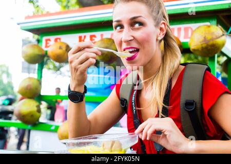 Femme européenne à manger cuisine mobile de voyage explorer décrochage sur Jakarta Indonésie street food Banque D'Images