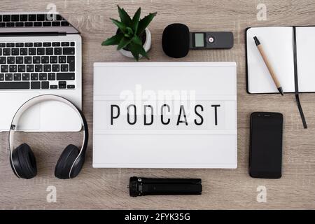 podcast et blogging concept - fond plat avec équipement d'enregistrement audio, visionneuse avec mot de podcast sur table en bois avec ordinateur portable, microphon Banque D'Images