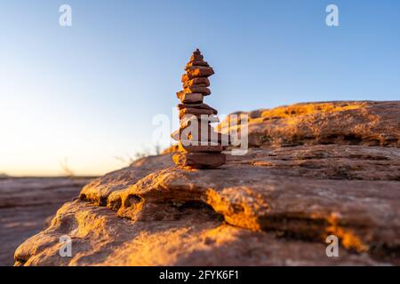 Pile de pierres (également appelée cairn, Steinmännchen ou Steinmandl) utilisée comme marqueur de randonnée ou de méditation, prise au coucher du soleil à l'État de Dead Horse point Banque D'Images