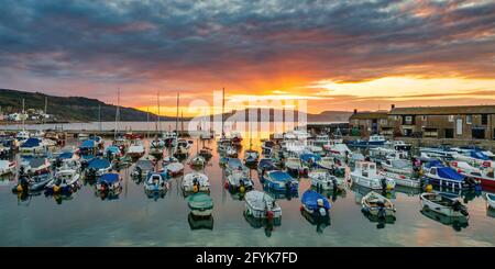 Un lever de soleil spectaculaire au port de Lyme Regis à Dorset. Banque D'Images