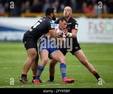 Leeds Rhinos Jack Broadbent est abordé par Castleford Tigers Liam Watts (à droite) et Suaia Matagi (à gauche) lors du match de la Super League de Betfred au stade de la Jungle du mend-A-looder, à Castleford. Date de la photo: Vendredi 28 mai 2021. Banque D'Images