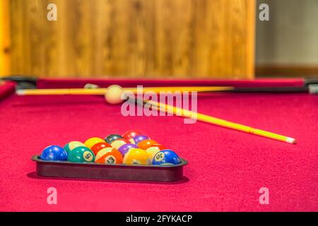 Table de billard rouge pastel avec boules dans un rack Banque D'Images