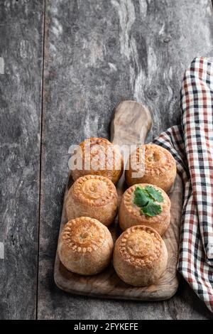 Mini-chaussons de porc Melton Mowbray sur une table en bois rustique Banque D'Images