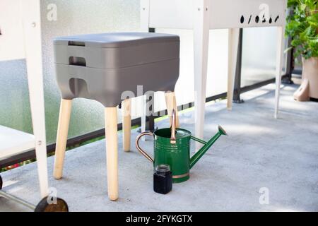 Un système de vermicomposter (worm composter) est installé sur un balcon d'appartement avec d'autres jardinières. Les vers mangent des restes de nourriture et produisent des moulages de vers et Banque D'Images