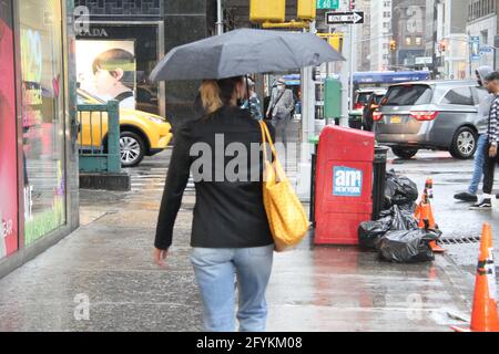 New York, États-Unis. 28 mai 2021. (NOUVEAU) précipitations à New York le week-end du Memorial Day. 28 mai 2021, New York, États-Unis: Les précipitations commencent aujourd'hui et tout au long du week-end du Memorial Day à New York. Les gens essaient de se protéger de la pluie en utilisant leurs parapluies, manteaux de pluie et protections improvisées pendant qu'ils préparent pour la célébration du Memorial Day. Crédit: Niyi Fote/Thenew2 crédit: Niyi Fote/TheNEWS2/ZUMA Wire/Alay Live News Banque D'Images