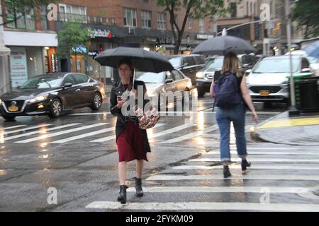 New York, États-Unis. 28 mai 2021. (NOUVEAU) précipitations à New York le week-end du Memorial Day. 28 mai 2021, New York, États-Unis: Les précipitations commencent aujourd'hui et tout au long du week-end du Memorial Day à New York. Les gens essaient de se protéger de la pluie en utilisant leurs parapluies, manteaux de pluie et protections improvisées pendant qu'ils préparent pour la célébration du Memorial Day. Crédit: Niyi Fote/Thenew2 crédit: Niyi Fote/TheNEWS2/ZUMA Wire/Alay Live News Banque D'Images