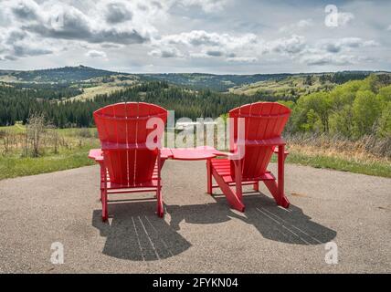 Deux chaises rouges surplombant le lieu historique national du fort-Walsh, dans les collines Cypress de la Saskatchewan, au Canada Banque D'Images