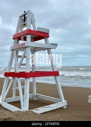 Chaise de maître nageur vide sur Tower Beach, le long de la côte de l'Illinois du lac Michigan, lors d'une journée de tempête alors que les vagues s'écrasont le long de la rive en arrière-plan. Banque D'Images