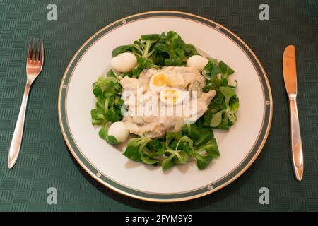Salade de poisson viennoise au hareng mariné appelé Heringsschmaus, Wiener Heringssaplat ou Fischsalat en Autriche, servie avec de la laitue d'agneau et de l'œuf de caille Banque D'Images