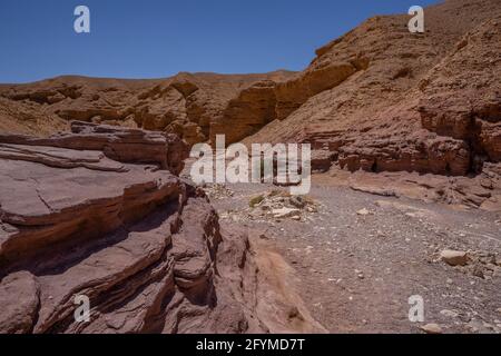 Roches sédimentaires rouges à côté des formations de calcaire dans le Red Canyon, près d'Eilat, en Israël, par une journée claire et ensoleillée. Banque D'Images