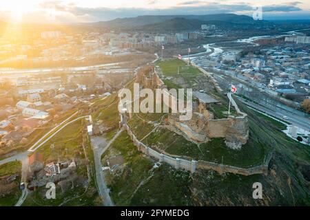 Vue panoramique aérienne de la forteresse médiévale de Gori, au sommet d'une colline au-dessus de la ville géorgienne de Gori, au coucher du soleil de printemps, dans la région de Shida Kartli Banque D'Images