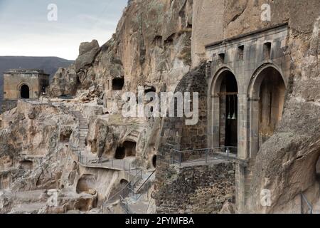 Complexe de la grotte de Vardzia structures de monastère sculptées sur le versant de la montagne avec vue du temple de l'Assomption de la Sainte Vierge Marie avec approfondi dans la roche Banque D'Images