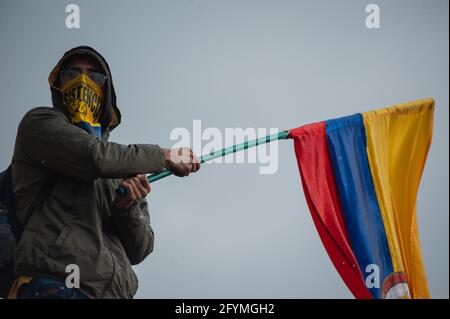 Bogota, Colombie. 28 mai 2021. Un manifestant fait brimer un drapeau colombien tandis que des milliers de personnes se sont rassemblées pour protester contre le président colombien Ivan Duque Maraquez et les cas de troubles et de brutalité policière qui ont fait au moins 45 morts au cours du premier mois de manifestations, à Bogota, en Colombie, le 28 mai 2021. Crédit : long Visual Press/Alamy Live News Banque D'Images