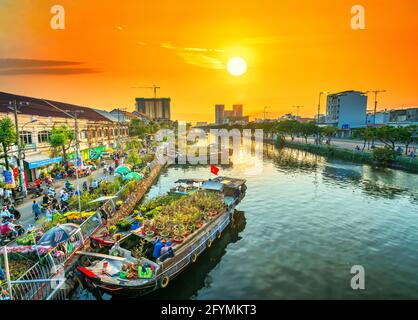 Marché aux fleurs quai bateau au coucher du soleil le long du quai du canal. C'est placer les agriculteurs à vendre abricot et d'autres fleurs sur Nouvel An lunaire à Ho Chi Minh Ville, Vietnam Banque D'Images
