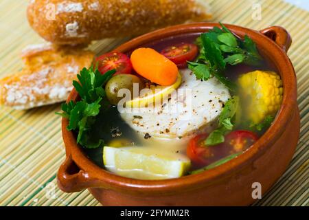 Une recette d'un potage de pêcheur : faire bouillir le bouillon de tête merluccius. Ajouter les pommes de terre, les carottes, les échalotes, le maïs, le poisson steak 200 g, sel, poivre. Porter à four, Banque D'Images