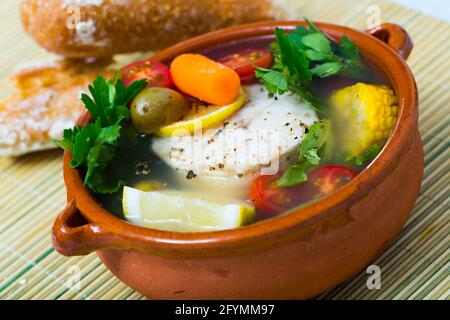 Une recette d'un potage de pêcheur : faire bouillir le bouillon de tête merluccius. Ajouter les pommes de terre, les carottes, les échalotes, le maïs, le poisson steak 200 g, sel, poivre. Porter à four, Banque D'Images