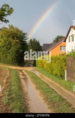 Liestal, Suisse - 21 septembre 2020 : un arc-en-ciel dans le ciel après une tempête à Seltisberg près de Liestal. Le chemin paysan est plein de flaques Banque D'Images