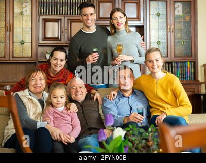 Portrait d'une grande famille heureuse qui se réunit dans la maison parentale, se posant ensemble sur un canapé Banque D'Images