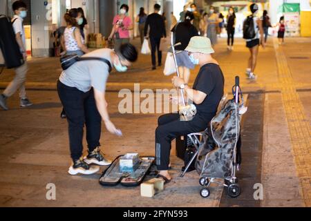 22 5 2021 interprète de rue joue erhu, ou un instrument de musique chinois à deux cordes, un violon à pointes. Le jeune homme donne de l'argent Banque D'Images