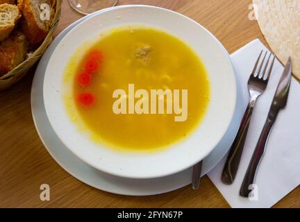 Soupe traditionnelle catalane de viande et de légumes Escudella dans une assiette blanche Banque D'Images