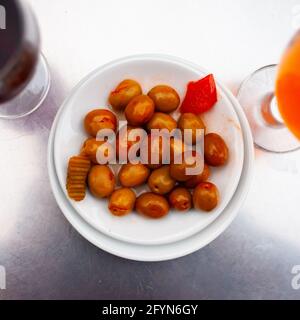 Assiette d'olives vertes sautées non dénoyautées sur la table. Tapas typiquement espagnoles Banque D'Images