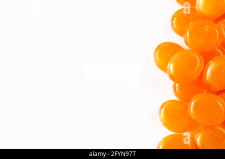 Gros plan de bonbons durs aux fruits sur fond blanc. Bonbons orange. Vue de dessus. Copier l'espace Banque D'Images