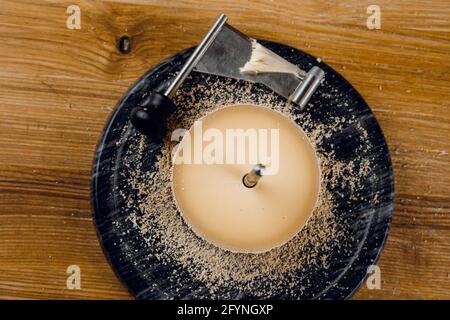 Rasage de la tête de moine à l'aide d'un couteau à girofle. Tête de moines. Variété de fromage semi-dur suisse à base de lait de vache. Banque D'Images