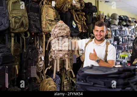 Positif adulte homme client choise sac de camouflage dans la boutique airsoft Banque D'Images