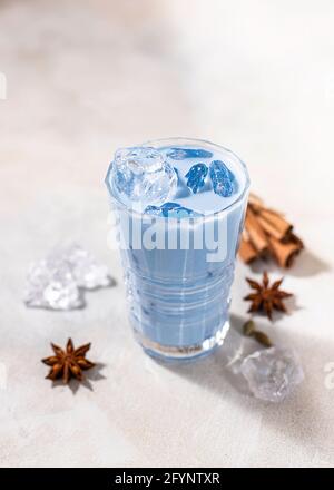 Latte matcha bleu en verre sur fond de béton clair. Thé thaïlandais bleu froid avec glace et lait. Gros plan, espace de copie. Banque D'Images