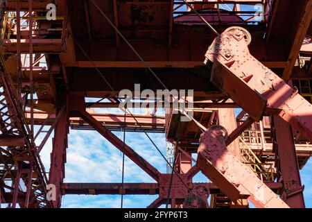 Vue à travers l'extérieur d'une installation industrielle vers le ciel bleu et les nuages au-delà, jour ensoleillé, aspect horizontal Banque D'Images