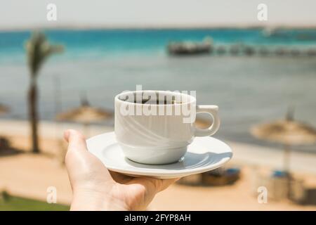 Les mains des femmes tiennent une tasse de café. Concept de lever du soleil du matin. Commençons une nouvelle journée. Espace pour le texte Banque D'Images