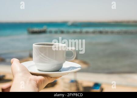 Les mains des femmes tiennent une tasse de café. Concept de lever du soleil du matin. Commençons une nouvelle journée. Espace pour le texte Banque D'Images