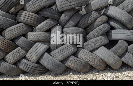 Les pneus de voiture sont empilés dans de grandes piles lors de la réparation de voiture boutique Banque D'Images