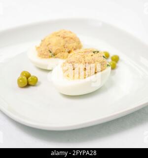Œufs farcis Niçoise. Cuisson. Demi-œufs remplis de thon en conserve Banque D'Images